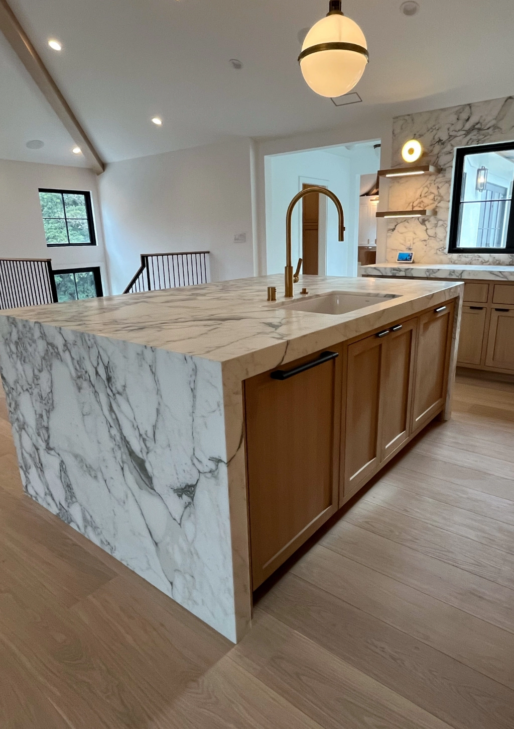 A luxury kitchen remodel with wooden floors and marble countertops.